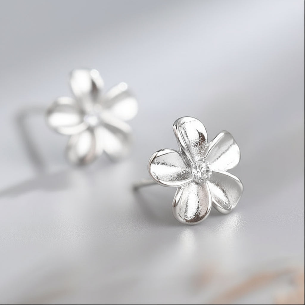 Silver flower-shaped earring on a light gray background