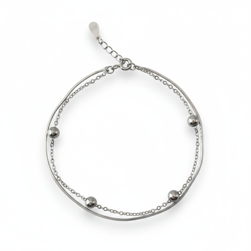Silver bracelet with small beads on a white background
