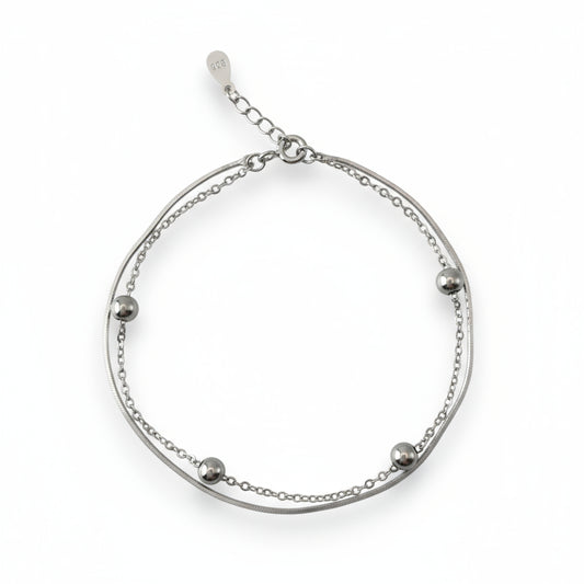 Silver bracelet with small beads on a white background