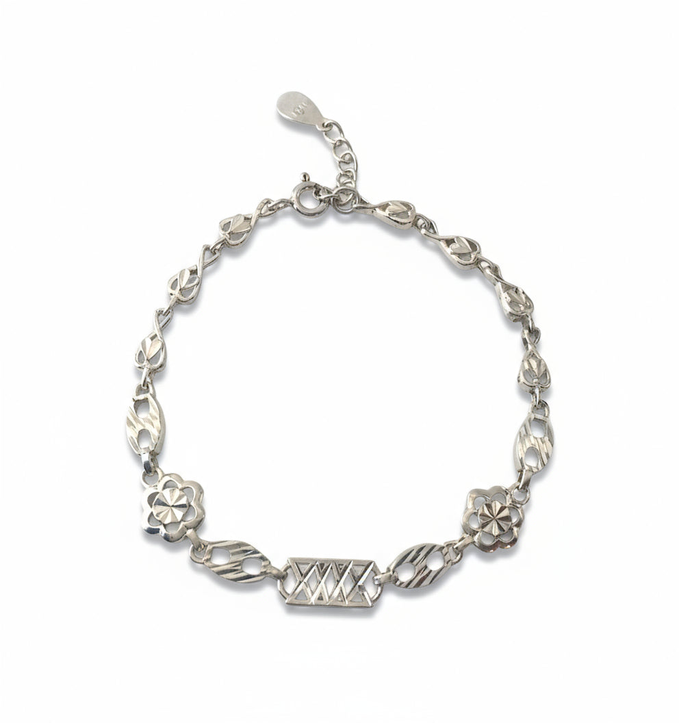 Silver bracelet with floral and geometric designs on a white background