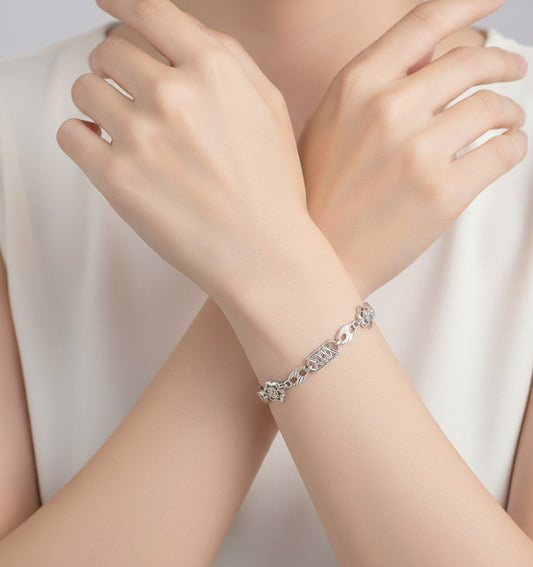 Silver bracelet with geometric designs on a white background