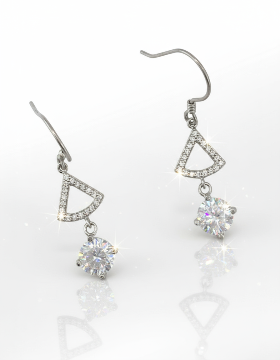 Pair of silver earrings with triangular designs and clear cubic zirconia on a white background