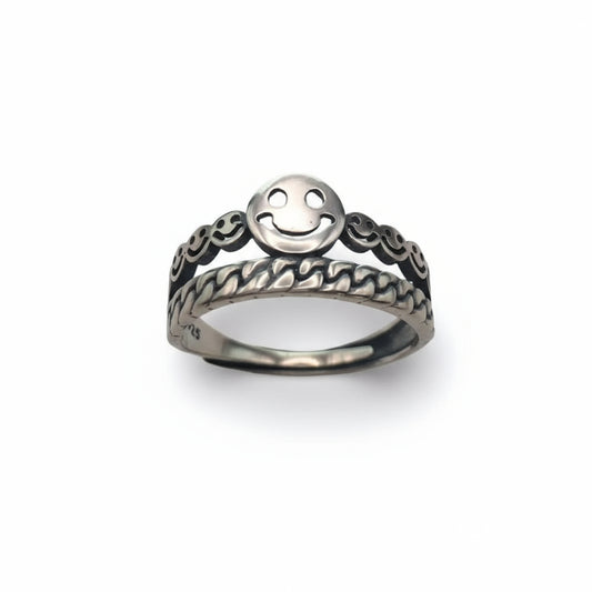 Silver ring with smiley face design on a white background