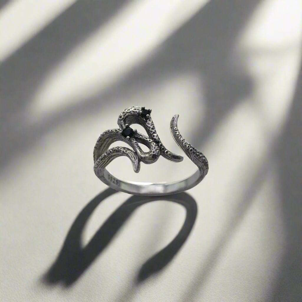 Silver ring with snake design on a light background