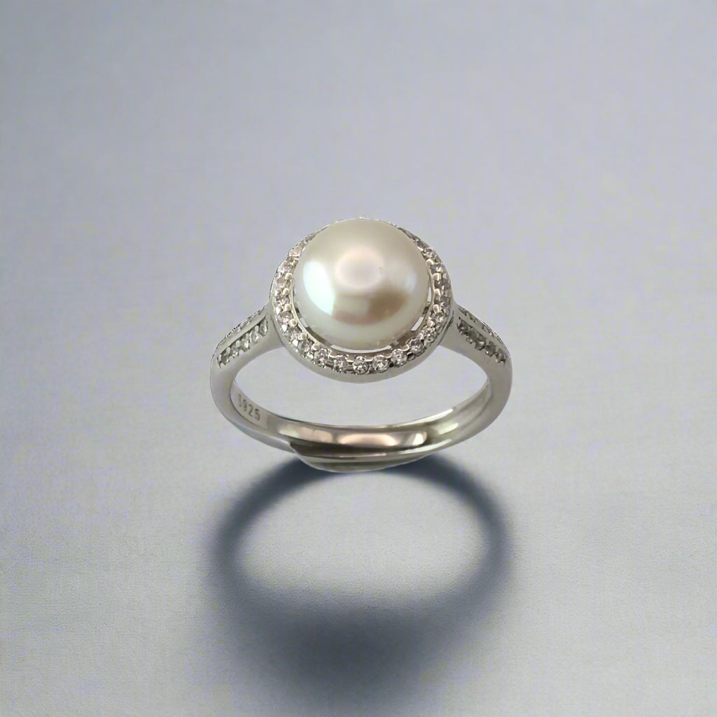 Pearl ring with silver band on a white background