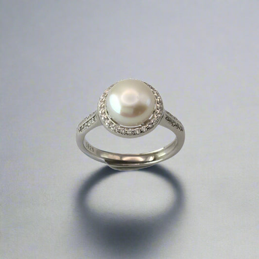 Pearl ring with silver band on a white background