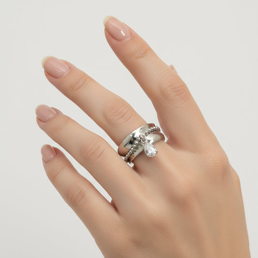 Silver ring with a teardrop-shaped gemstone on a gray background