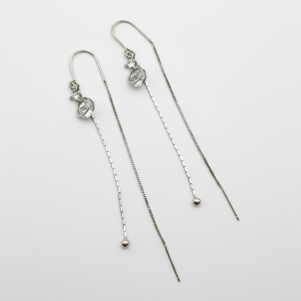 Pair of silver threader earrings on a white background