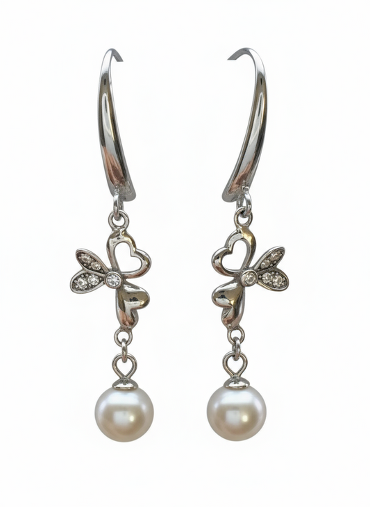 Pair of silver earrings with butterfly designs and pearl drops on a white background