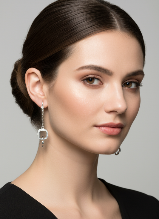 Pair of silver earrings with chain details on a white background