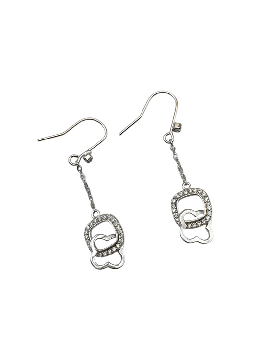 Pair of silver earrings with heart designs on a white background