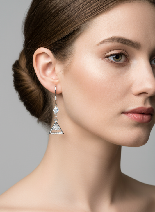 Pair of silver triangle earrings with clear stones on a white background