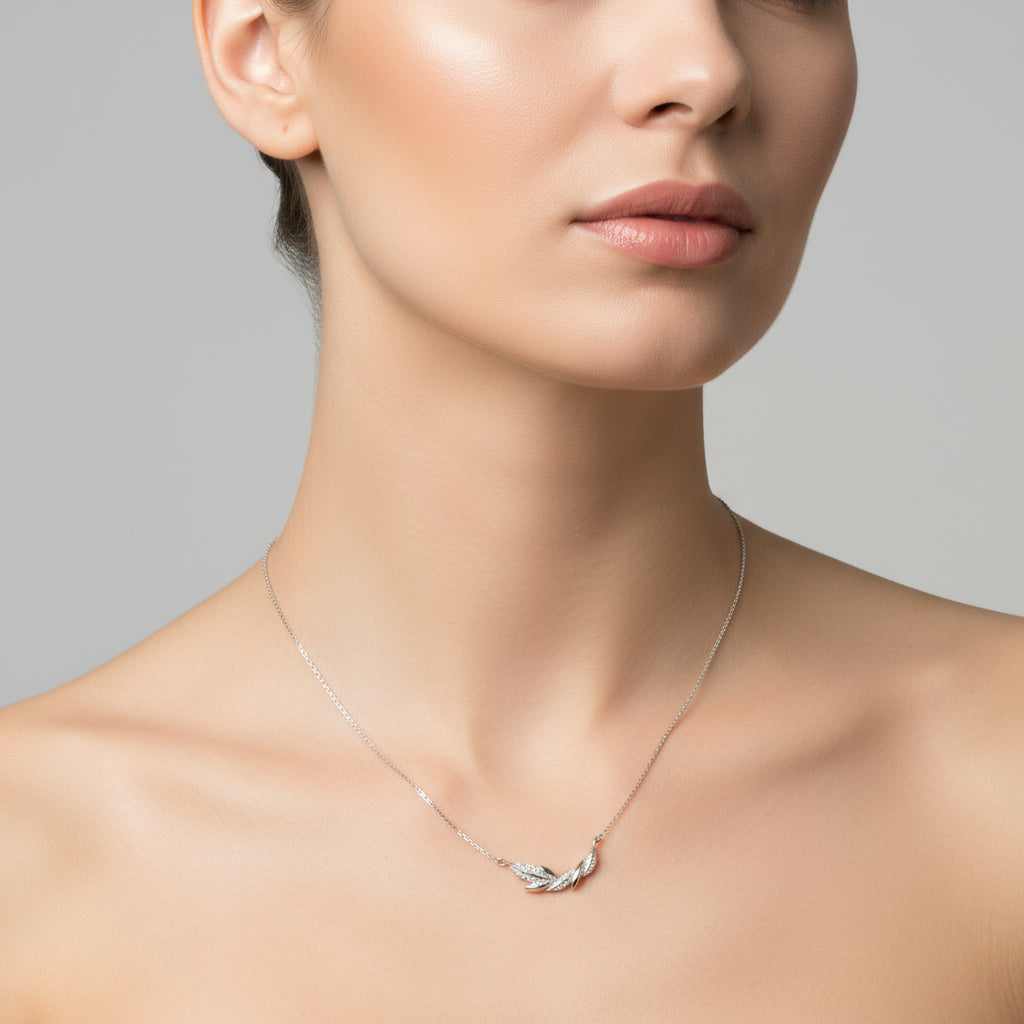 Silver necklace with a feather pendant on a white background