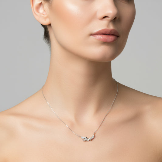Silver necklace with a feather pendant on a white background