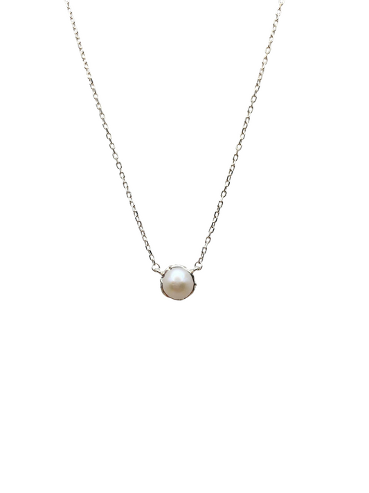 Pearl necklace on a thin chain against a white background