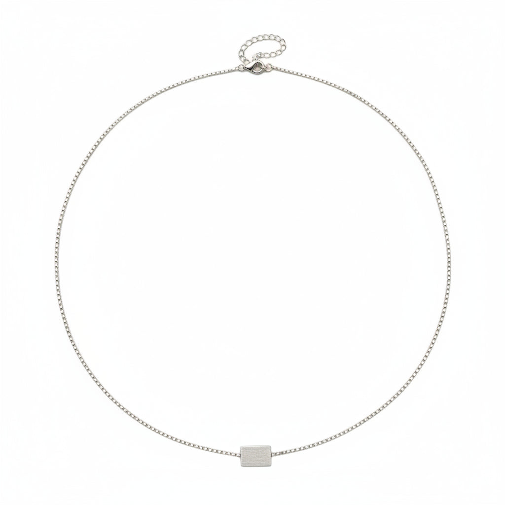 Silver necklace with a square pendant on a white background