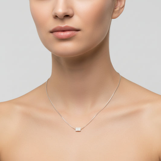 Silver necklace with a square pendant on a white background