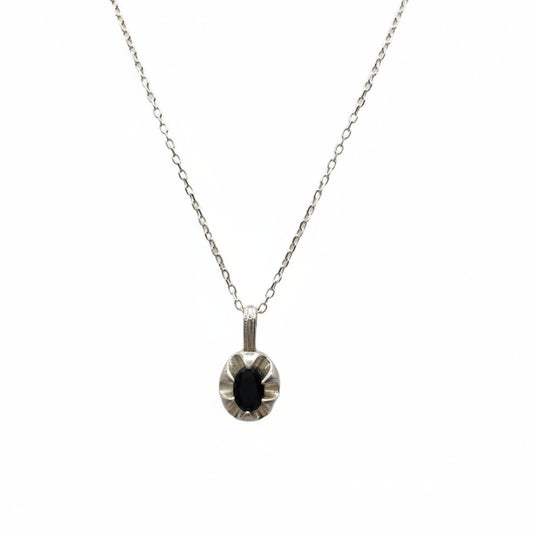 Necklace with a round pendant featuring a black gemstone on a white background