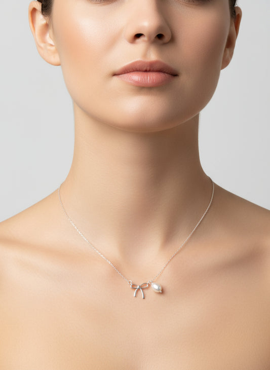 Necklace with bow and leaf pendant on a white background
