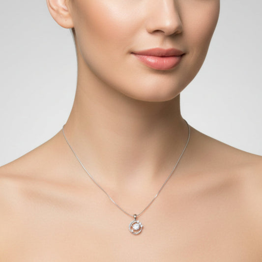 Silver necklace with a small round pendant on a white background