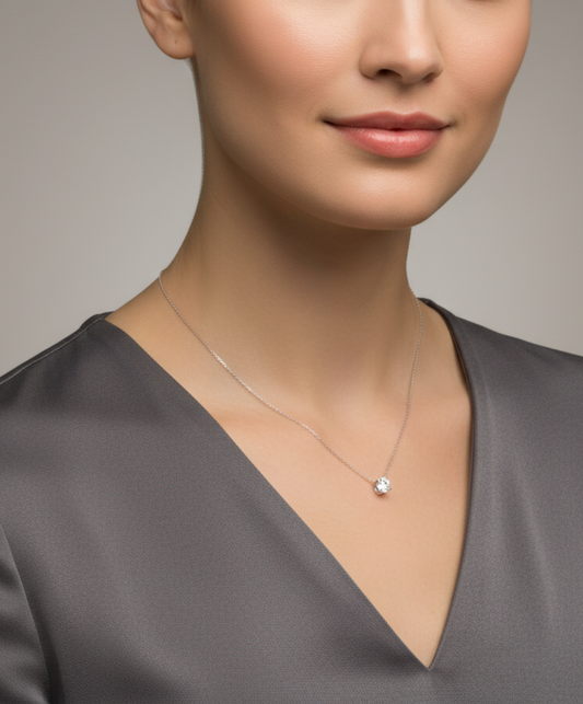 Silver necklace with a small pendant on a white background