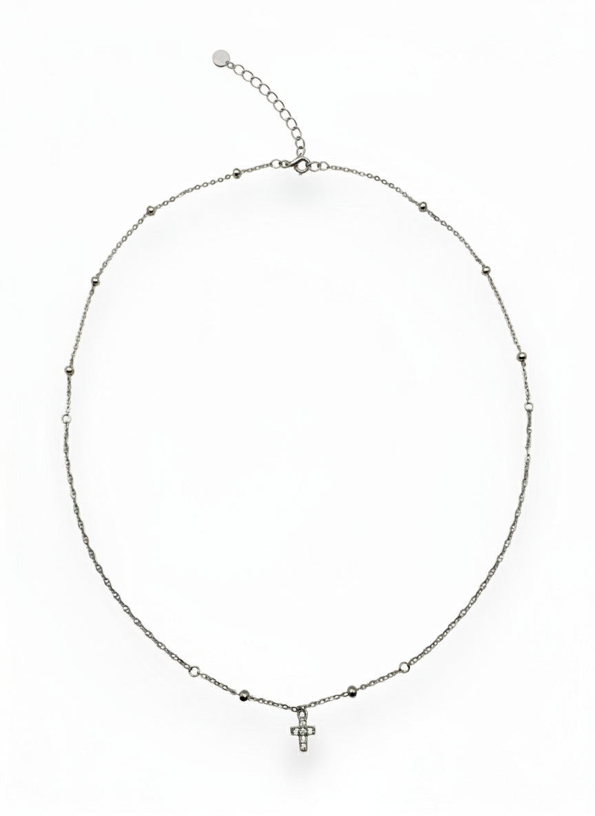Silver necklace with a small cross pendant on a white background