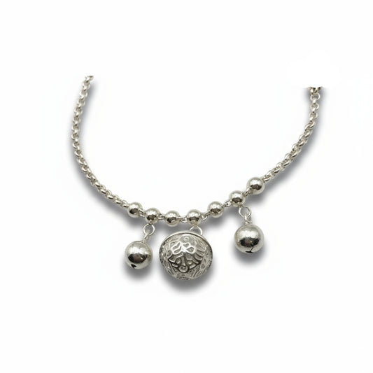 Silver bracelet with three charms on a white background