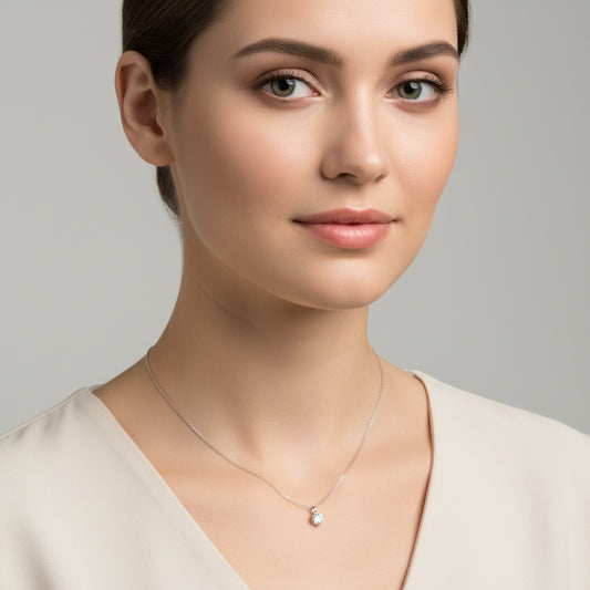 Silver necklace with a small pendant on a white background