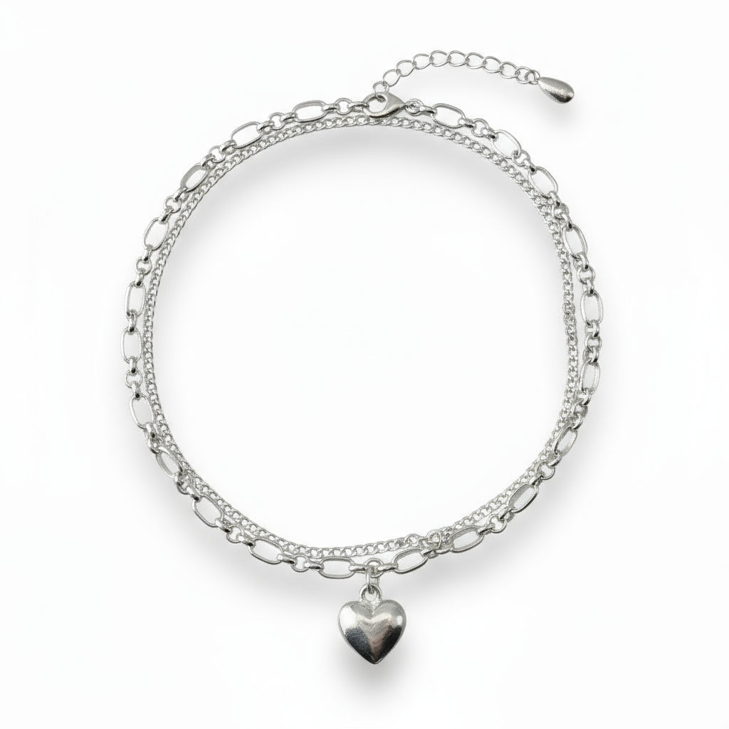 Silver bracelet with heart charm on a white background