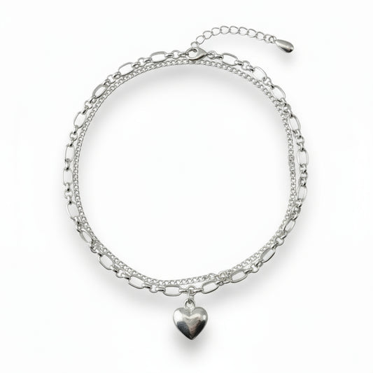 Silver bracelet with heart charm on a white background