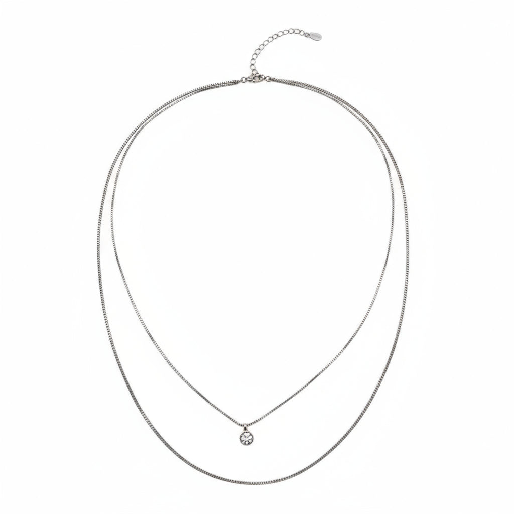Silver necklace with a small pendant on a white background