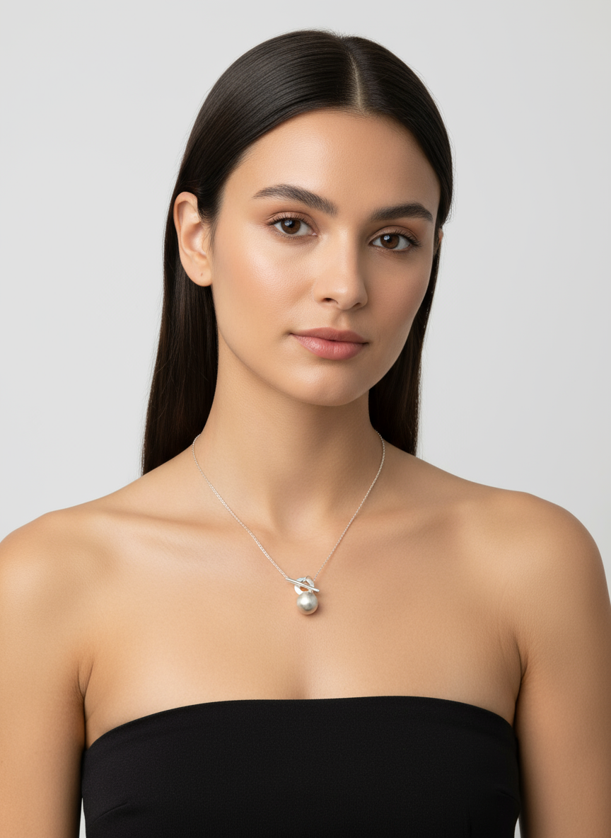 Silver necklace with a small pendant on a white background