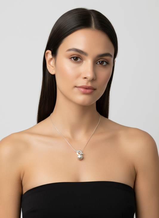 Silver necklace with a small pendant on a white background