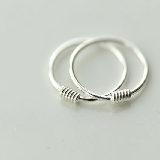 Silver hoop earrings on a light gray background