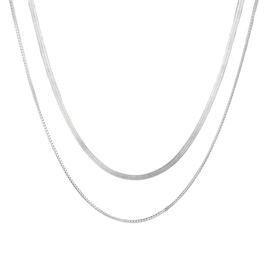 Silver chain necklace on a light gray background