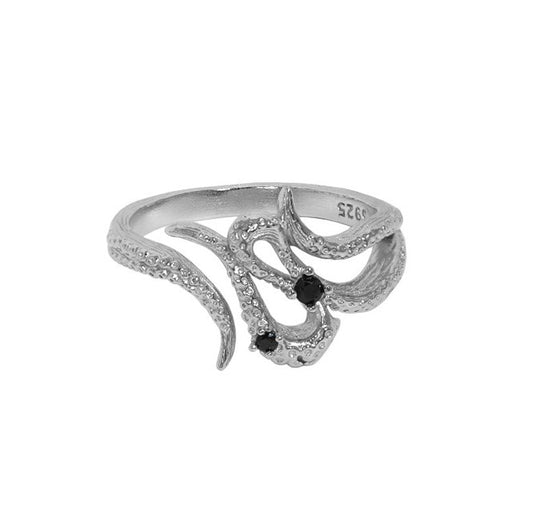 Silver ring with black gemstones on a white background