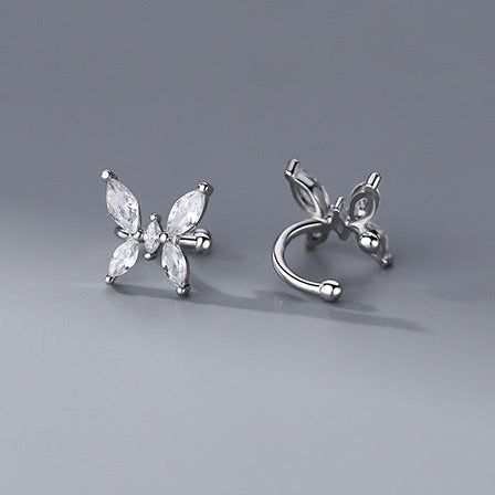 Butterfly-shaped silver earrings on a gray background