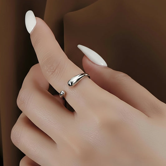 Hand wearing a silver ring with a plain background