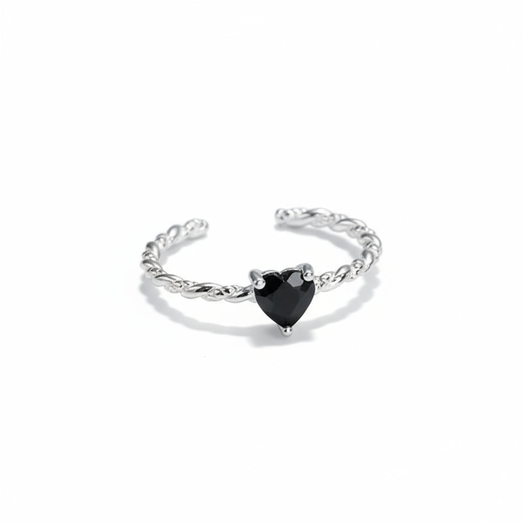 Silver ring with a black heart-shaped gemstone on a white background