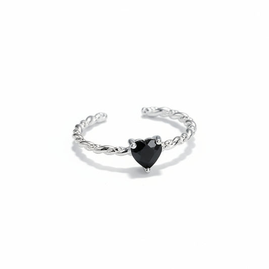 Silver ring with a black heart-shaped gemstone on a white background