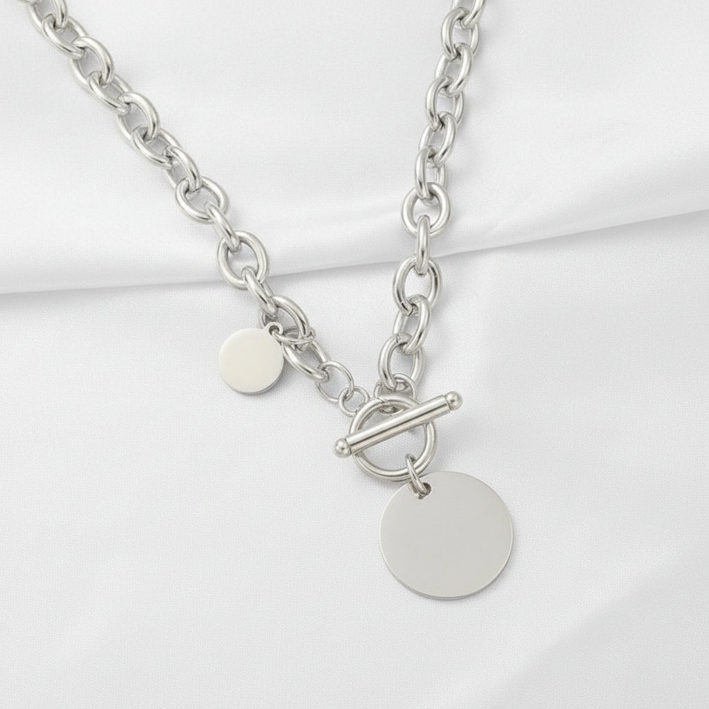 Silver chain necklace with round pendants on a pink satin background
