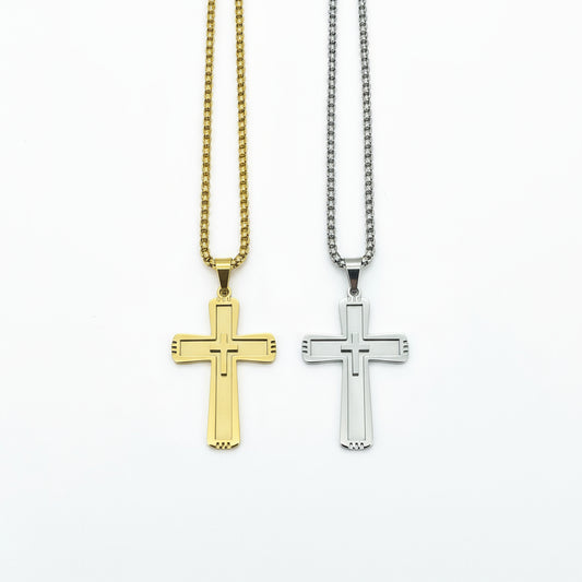 Gold and silver cross pendants on chains against a dark wooden background