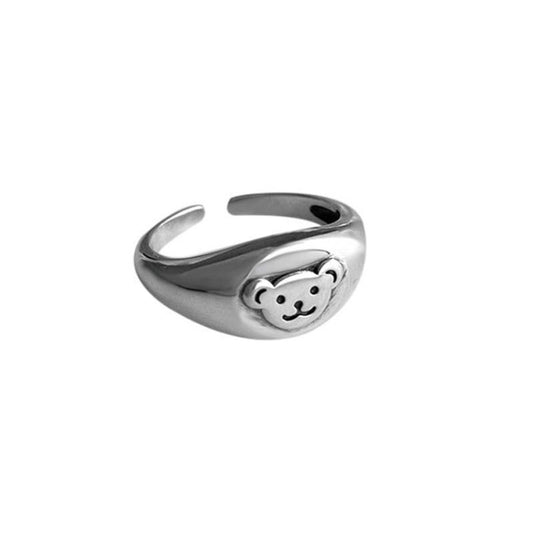 Silver ring with a teddy bear face design on a white background