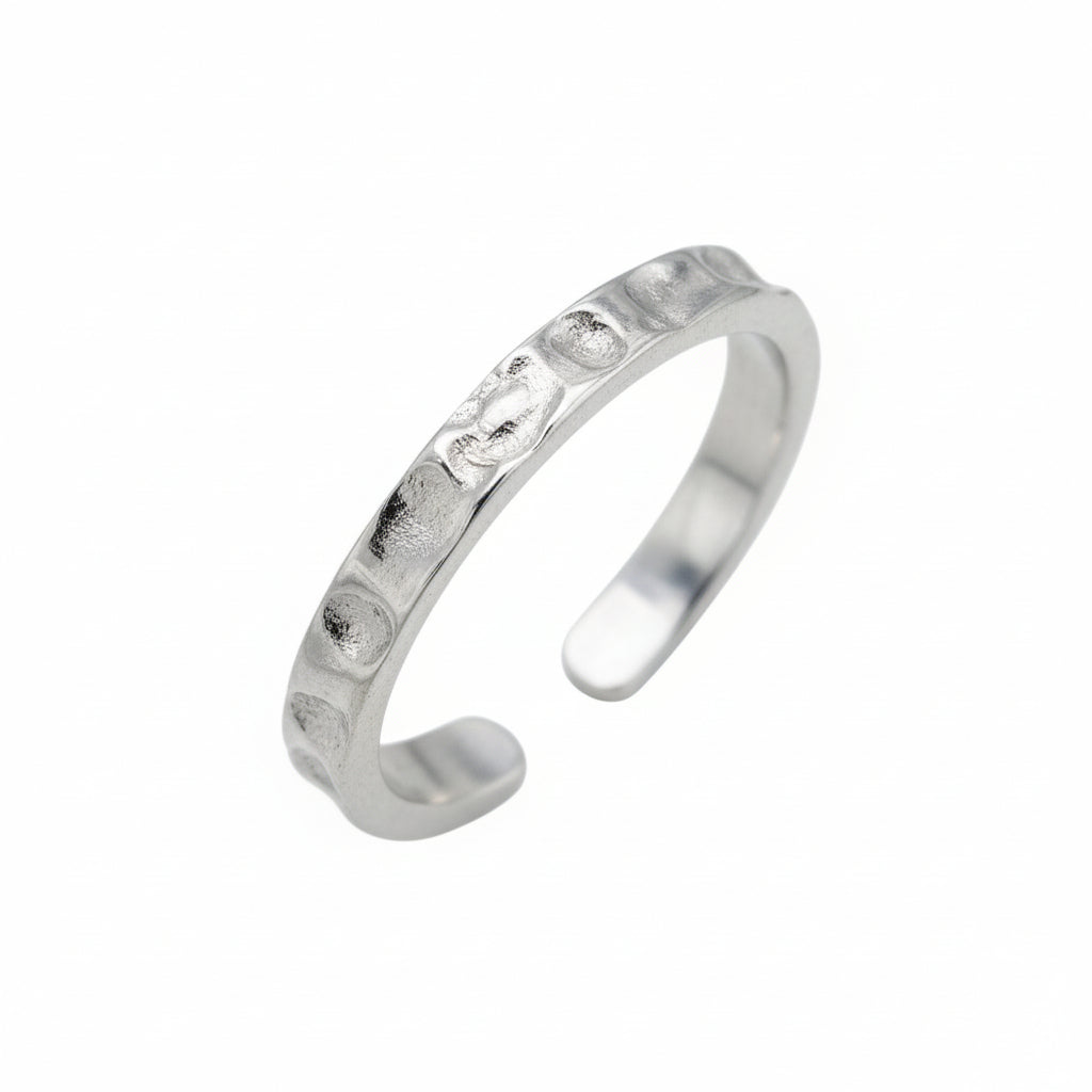 Silver toe ring with small stones on a white background