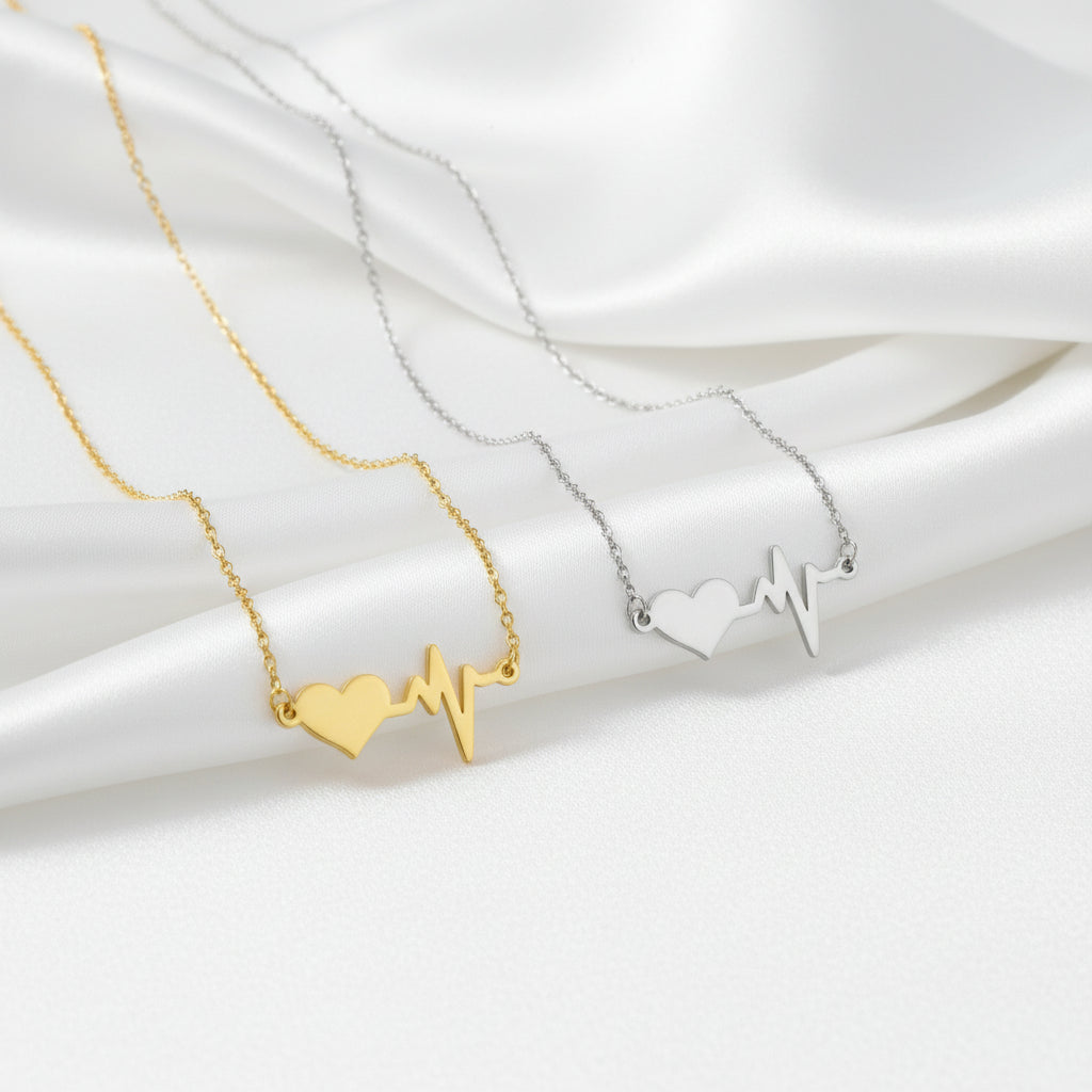 Gold necklace with a heart and heartbeat design on a white background