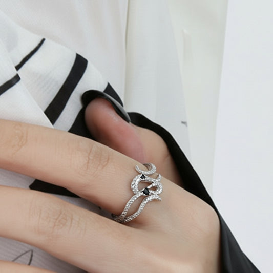 Hand with black nail polish wearing two silver ring.