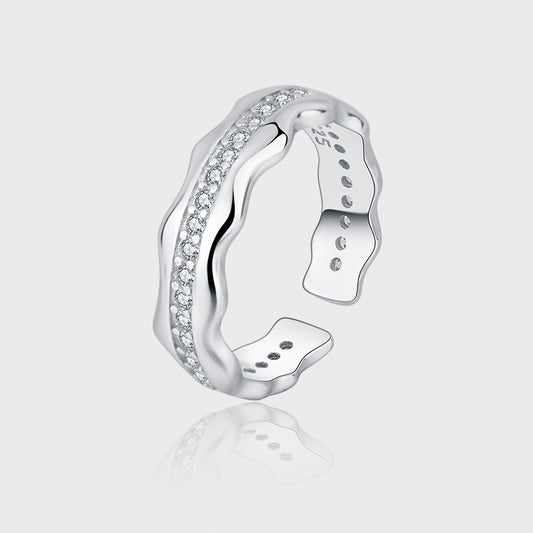 Silver ring with diamond accents on a light gray background
