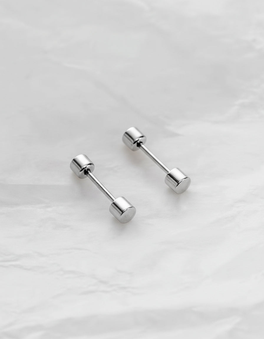 Pair of silver barbell-shaped earrings on a light gray background