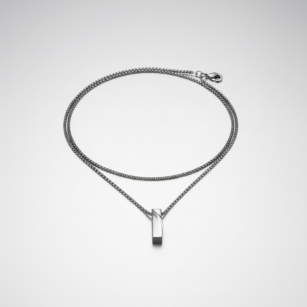 Silver chain necklace with a rectangular pendant on a white background