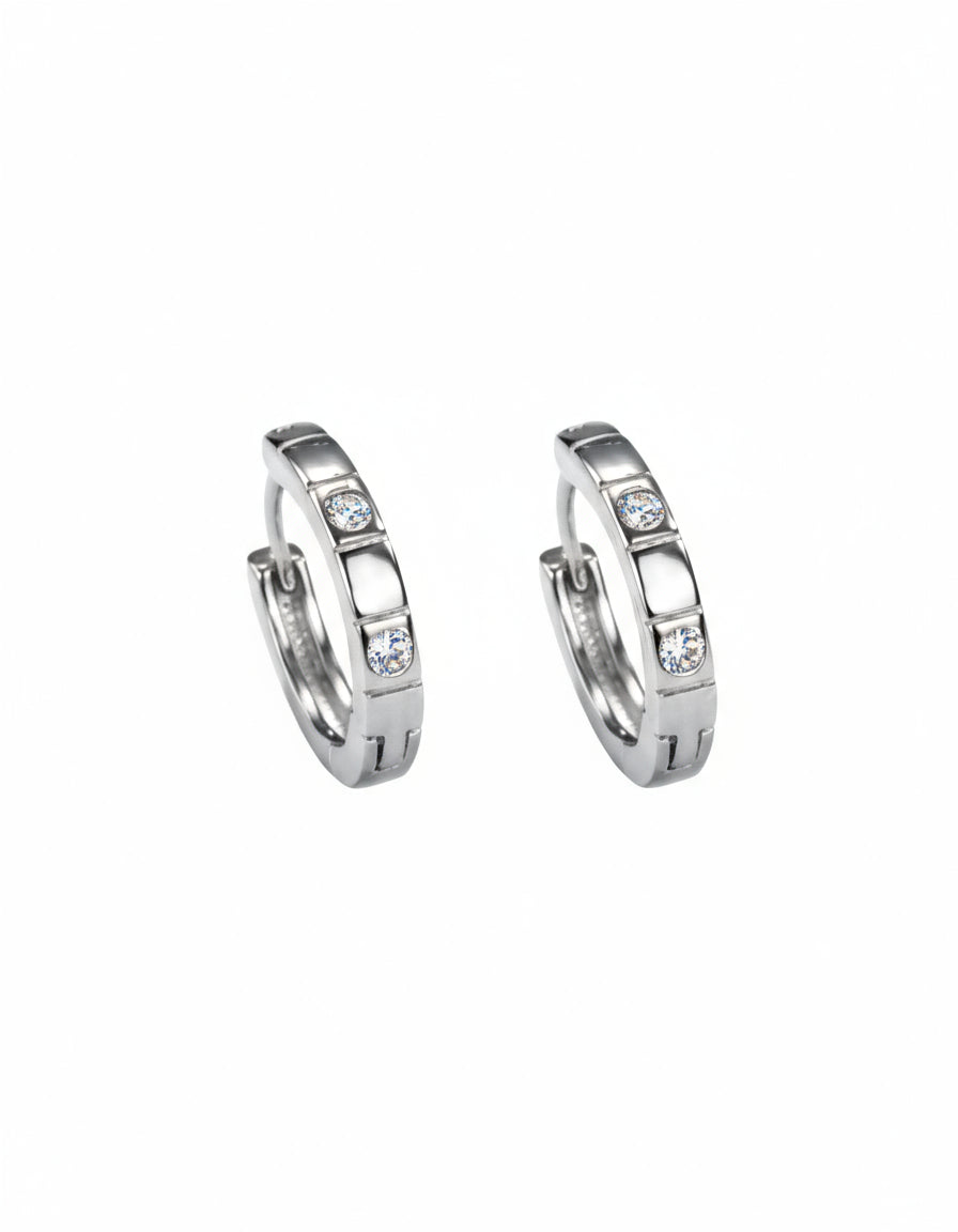 Pair of silver hoop earrings with embedded stones on a white background